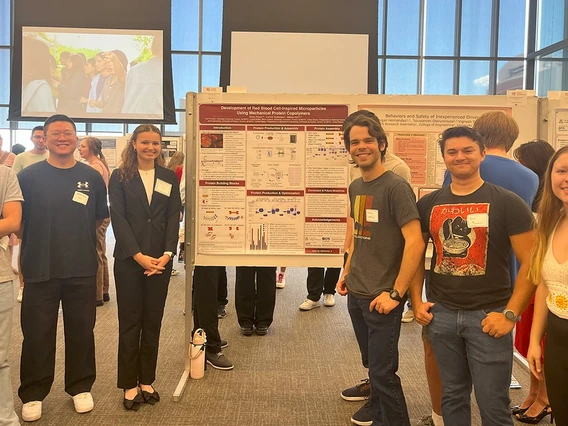 Students stand around a poster.