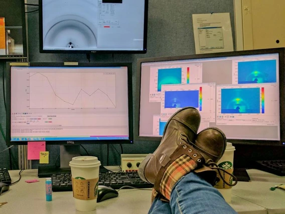 photo of feet on table, in front of computer screens