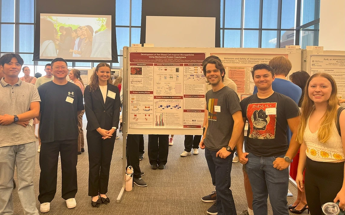 Students stand around a poster.