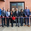 Nine people cut a ribbon.